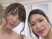 Dos chicas japonesas mojadas sirviendo a un chico